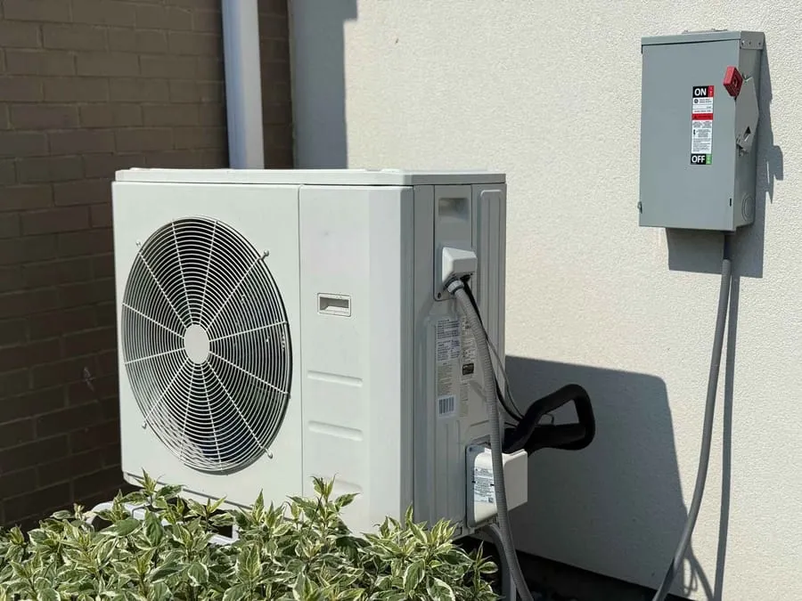 Modern heat pump on the side of a residential home